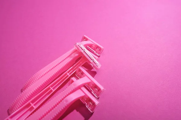 Disposable feminine razors on pink background with copy space — Stock Photo