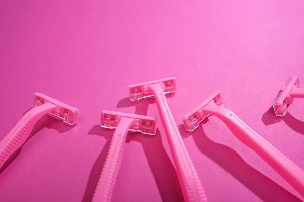 Одноразові жіночі бритви на рожевому фоні з копіювальним простором — стокове фото