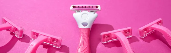 Panoramic shot of feminine razors on pink background — Stock Photo