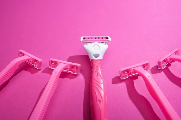 Maquinillas de afeitar femeninas sobre fondo rosa con espacio para copiar - foto de stock