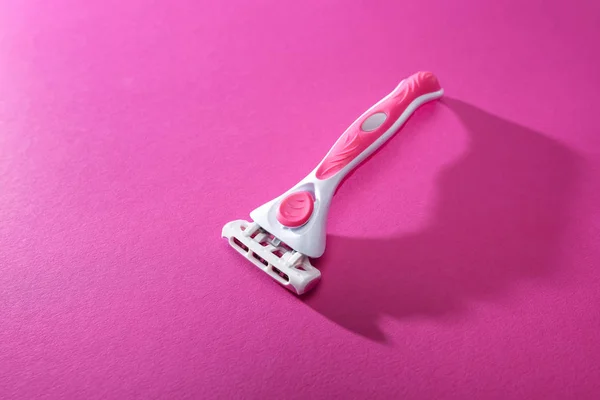 Feminine razor on pink background with copy space — Stock Photo