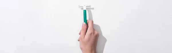 Cropped view of woman holding green disposable razor on white background, panoramic shot — Stock Photo