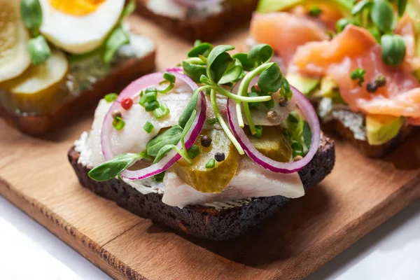 Selective focus of of herring fish fillet on tasty danish smorrebrod on white — Stock Photo