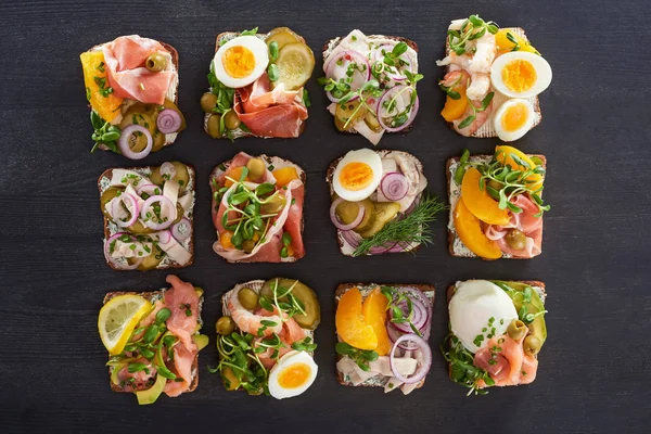 Vista superior de sándwiches de smorrebrod preparados en superficie gris - foto de stock