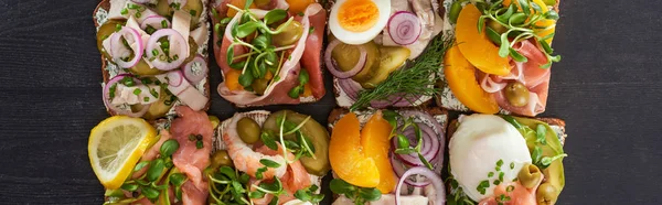 Панорамный снимок традиционных сморребровых бутербродов на серой поверхности — стоковое фото