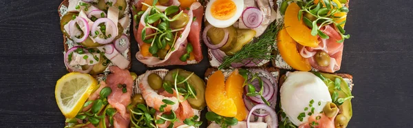 Panoramic shot of traditional smorrebrod sandwiches on grey surface — Stock Photo