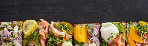 Панорамний знімок традиційних приготованих бутербродів на сірій поверхні — стокове фото