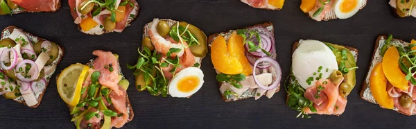 Plan panoramique de pain de seigle avec de savoureux sandwichs smorrebrod à la surface grise — Photo de stock