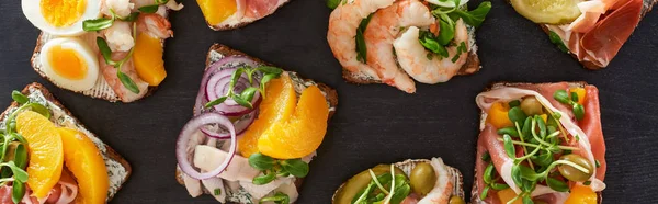 Plano panorámico de pan de centeno con sándwiches de smorrebrod preparados en la superficie gris - foto de stock