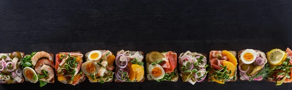 Panoramic shot of fresh danish smorrebrod sandwiches on grey surface — Stock Photo