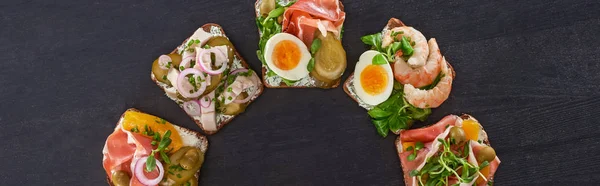 Plano panorámico de sándwiches de smorrebrod fresco con huevos cocidos en la superficie gris - foto de stock