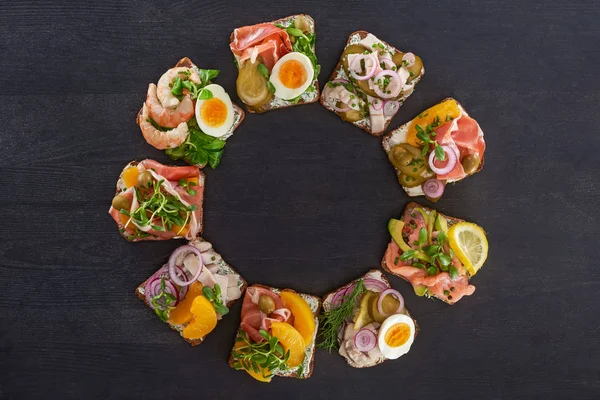 Tendido plano con sabrosos sándwiches smorrebrod con duraznos enlatados en la superficie gris - foto de stock