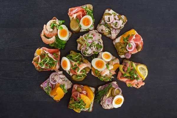 Flat lay with danish smorrebrod sandwiches with canned peaches and eggs on grey surface — Stock Photo