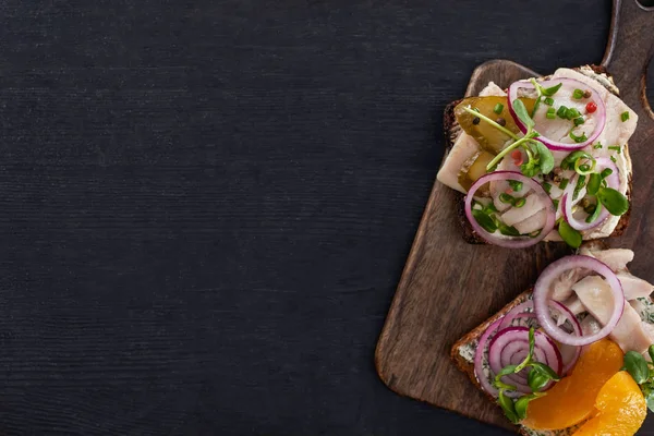 Vista superior de sabrosos sándwiches de smorrebrod sobre pan de centeno en superficie gris - foto de stock