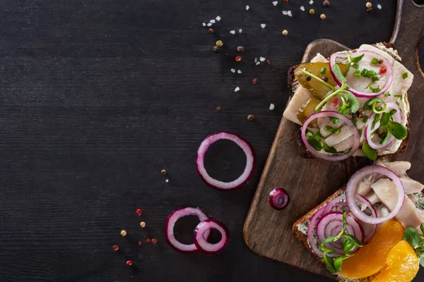 Vista superior de sabrosos sándwiches de smorrebrod en pan de centeno cerca de granos de pimienta en la superficie gris — Stock Photo