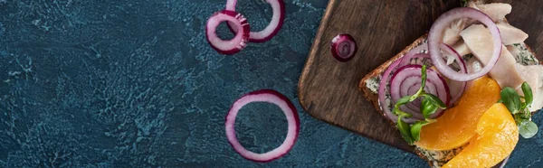 Tiro panorâmico de pão de centeio com sanduíche smorrebrod saboroso na superfície azul — Fotografia de Stock