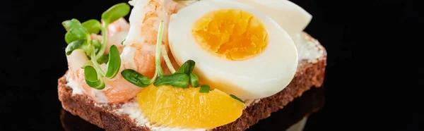 Tiro panorâmico de pão de centeio com delicioso camarão perto de ovo em sanduíche de smorrebrod em preto — Fotografia de Stock