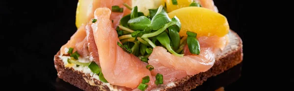 Panoramic shot of salmon on tasty smorrebrod sandwich on black — Stock Photo