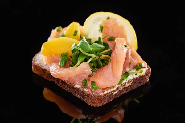 Close up de salmão em delicioso sanduíche de smorrebrod em preto — Fotografia de Stock