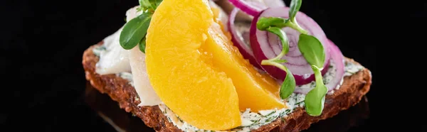 Panoramic shot of canned peaches on delicious smorrebrod sandwich on black — Stock Photo