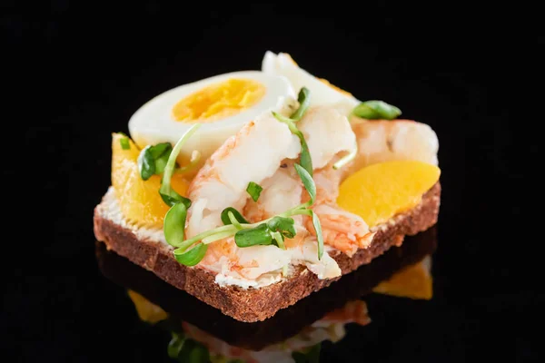 Gros plan de crevettes savoureuses sur sandwich smorrebrod sur noir — Photo de stock