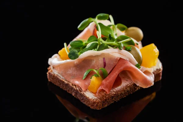 Primo piano di prosciutto su panino preparato danese smorrebrod su nero — Foto stock