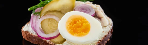 Panoramic shot of boiled egg on tasty danish smorrebrod sandwich on black — Stock Photo