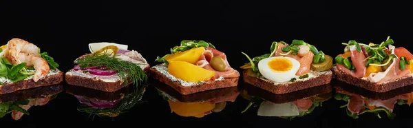 Panoramablick auf Roggenbrot mit schmackhaften dänischen Smorrebrod-Sandwiches auf Schwarz — Stockfoto