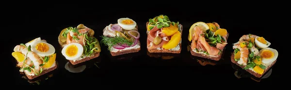 Plano panorámico de pan de centeno con sándwiches de smorrebrod danés preparados en negro - foto de stock