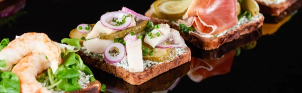 Panoramic shot of tasty smorrebrod sandwiches on black — Stock Photo