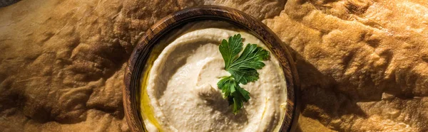 Vista superior del delicioso hummus en un tazón de pita recién horneada, plano panorámico - foto de stock