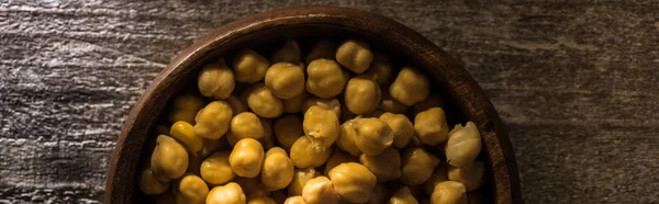 Top view of chickpeas in bowl on wooden rustic table, panoramic shot — Stock Photo