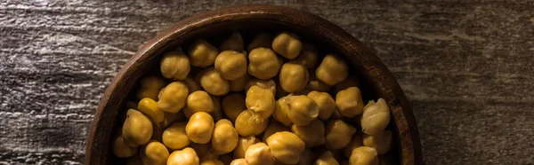 Vue du dessus des pois chiches dans un bol sur une table rustique en bois, vue panoramique — Photo de stock