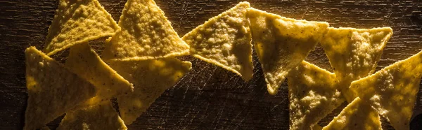 Vista dall'alto di deliziosi nachos croccanti di mais su tavolo rustico in legno, colpo panoramico — Foto stock