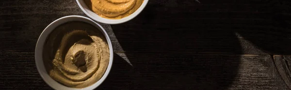 Top view of delicious assorted hummus on wooden rustic table, panoramic shot — Stock Photo