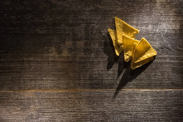 Vue de dessus de délicieux nachos de maïs croustillants sur table rustique en bois — Photo de stock