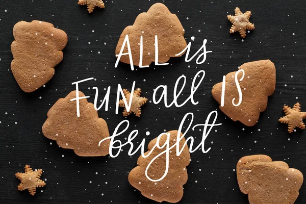 Vista dall'alto di fiocco di neve e biscotti dell'albero di Natale su tavolo di legno nero con tutto è divertente tutto è illustrazione luminosa — Foto stock