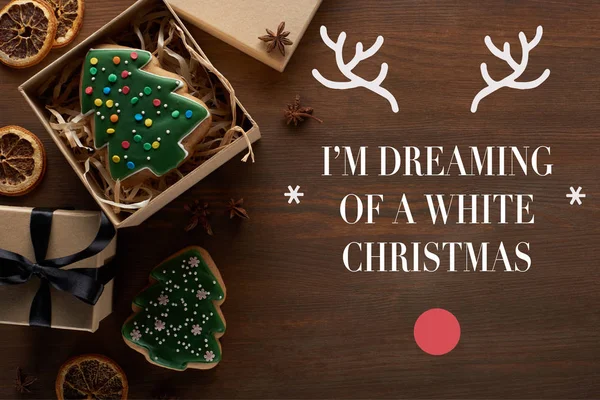 Вид зверху ялинкове печиво в подарунковій коробці на дерев'яному столі з я мрію про біле різдвяне написання — стокове фото
