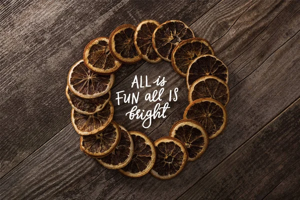 Round frame of dried orange slices on wooden background with all is fun all is bright lettering — Stock Photo