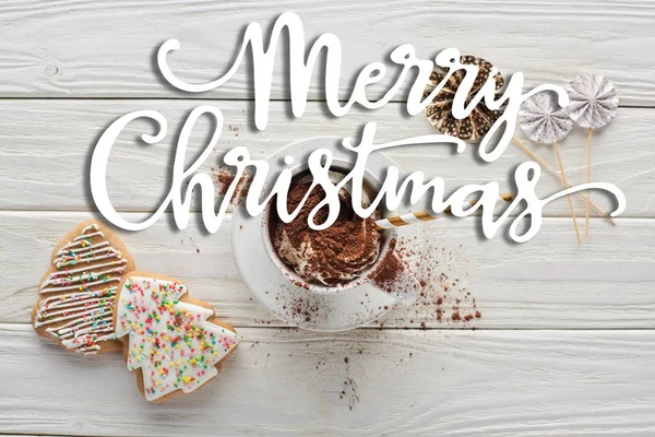 Vista superior de biscoitos de Natal e cacau na caneca com decoração na mesa de madeira branca com letras Feliz Natal — Fotografia de Stock