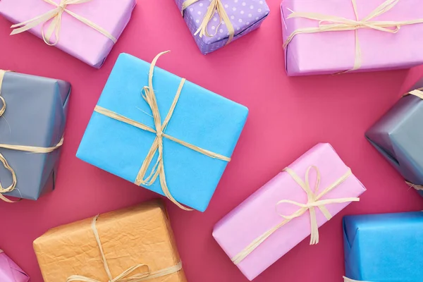 Top view of colorful presents with bows on crimson — Stock Photo