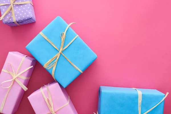 Top view of colorful gifts with bows on crimson — Stock Photo