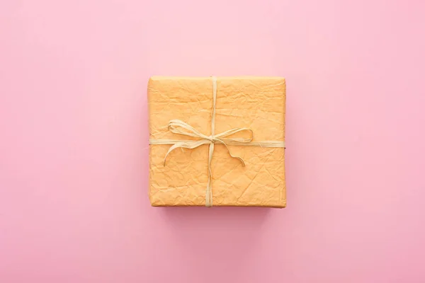 Top view of wrapped orange present on pink — Stock Photo