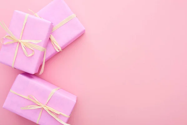 Top view of gift boxes with bows isolated on pink — Stock Photo