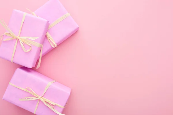 Vista dall'alto di scatole regalo con fiocchi isolati su rosa — Foto stock