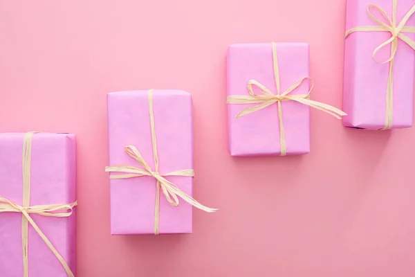 Top view of wrapped presents with bows on pink — Stock Photo