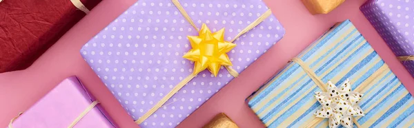 Plan panoramique de boîtes-cadeaux enveloppées sur rose — Photo de stock
