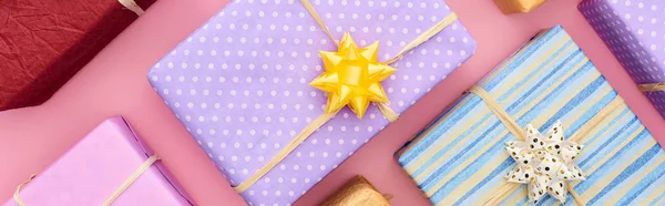 Plan panoramique de boîtes-cadeaux enveloppées avec des arcs sur rose — Photo de stock
