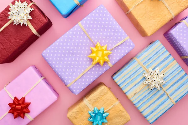 Vue du dessus des boîtes-cadeaux enveloppées avec des arcs sur rose — Photo de stock