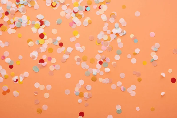 Декоративные и красочные конфетти на оранжевом фоне — стоковое фото